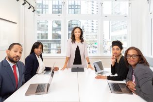 woman-standing-on-the-center-table-with-four-people-on-the-1367271-315x210  