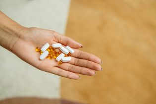 Woman Holding a Handful of Supplements