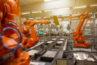 Close Up of Orange Robots in a Manufacturing Plant