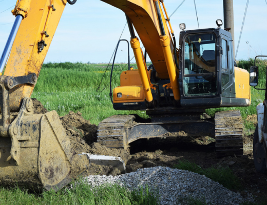 Yellow Backhoe in a Field