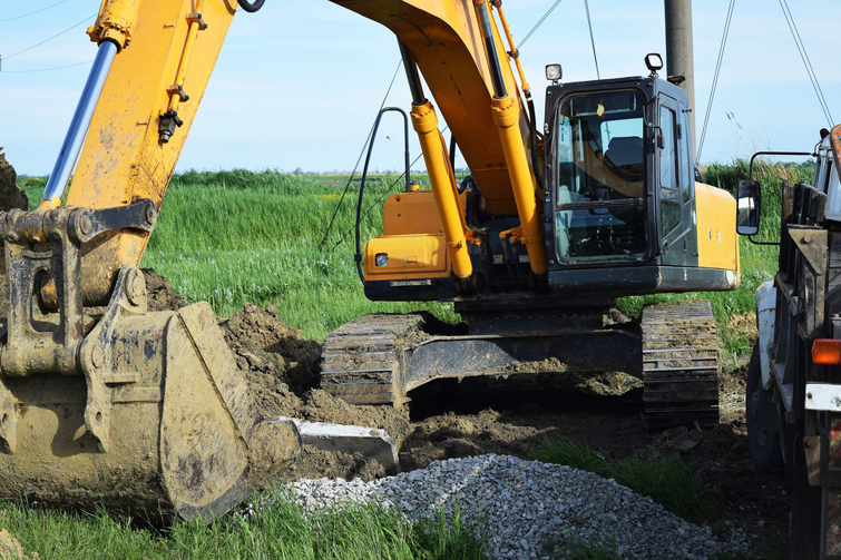 Yellow Backhoe in a Field