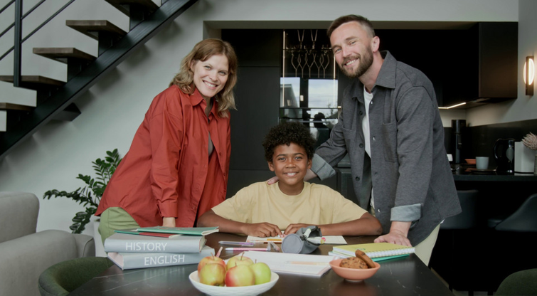 2 Parents Standing Beside an Adopted Child