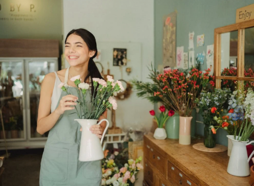 Woman Holding a Vase of Flowers in a Flower Shop