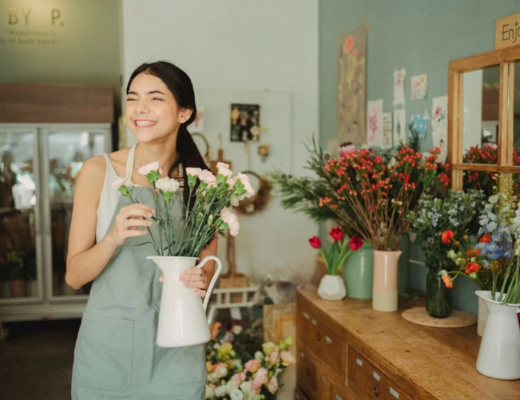 Woman Holding a Vase of Flowers in a Flower Shop