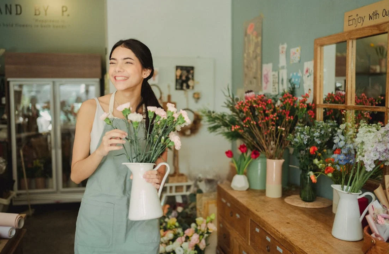 Woman Holding a Vase of Flowers in a Flower Shop