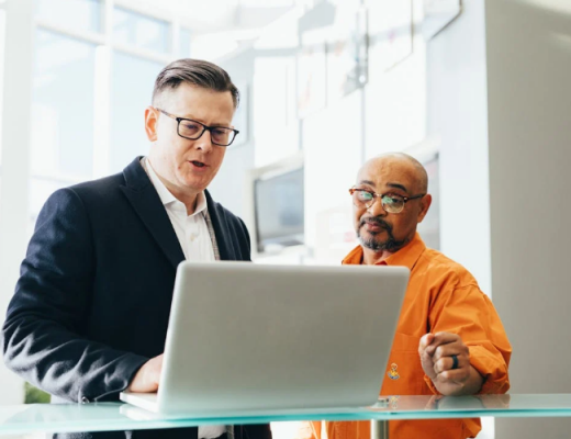 2 Men Standing and Looking at a Laptop