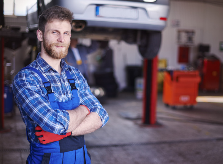 Caucasian Man Standing with Folded Arms in an Auto Repair Shop