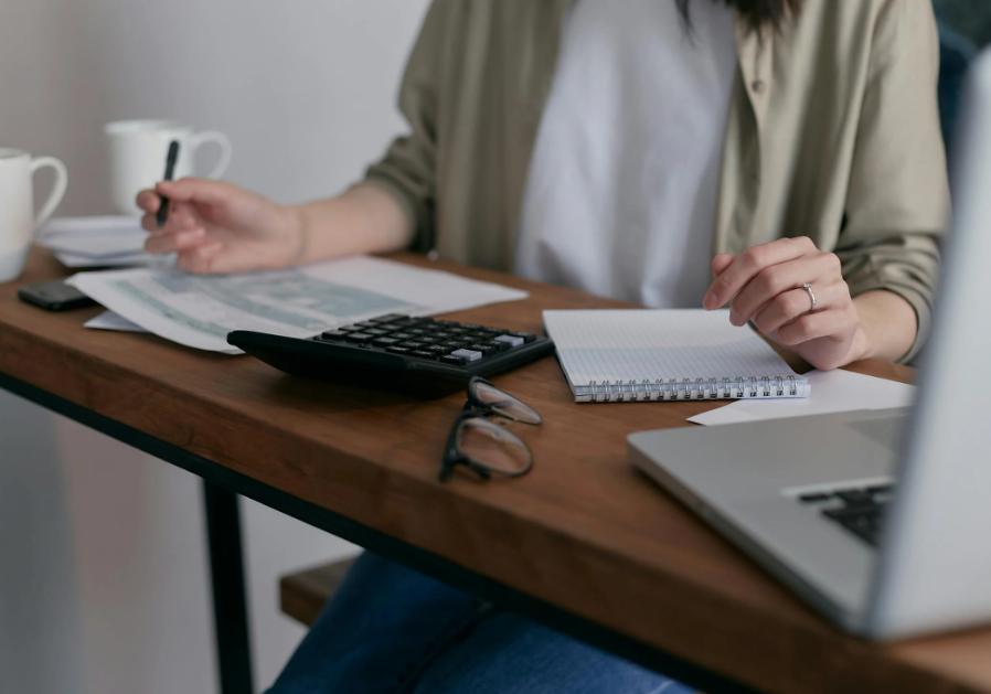 Woman Sitting at a Desk and Balancing Her Bank Account