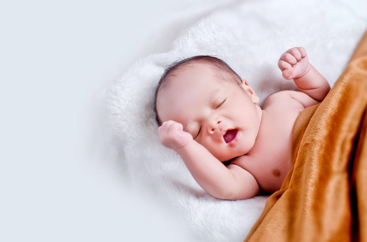 Yawning Baby Wrapped in Orange Blanket