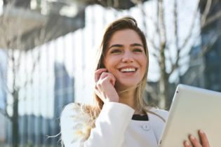 Smiling Caucasian Woman with Blonde Hair Talking on a Smartphone