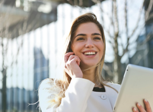 Smiling Caucasian Woman with Blonde Hair Talking on a Smartphone