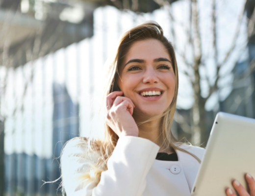 Smiling Caucasian Woman with Blonde Hair Talking on a Smartphone