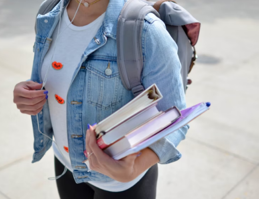 Young Student Wearing a Denim Jacket and Carrying 3 Books