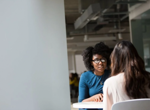 2 Woman Sitting at an Conference Table