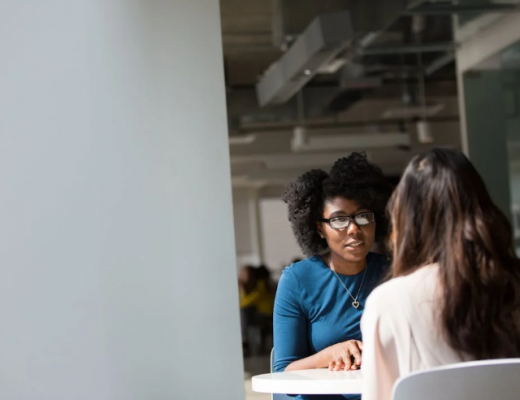 2 Woman Sitting at an Conference Table