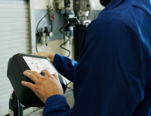 Man Using a Computer to Run Diagnostics on a Car