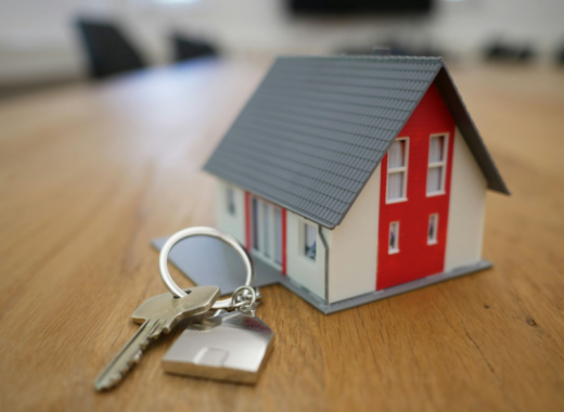 Replica of a House Sitting Next to a House Key