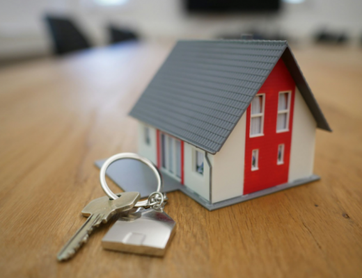Replica of a House Sitting Next to a House Key