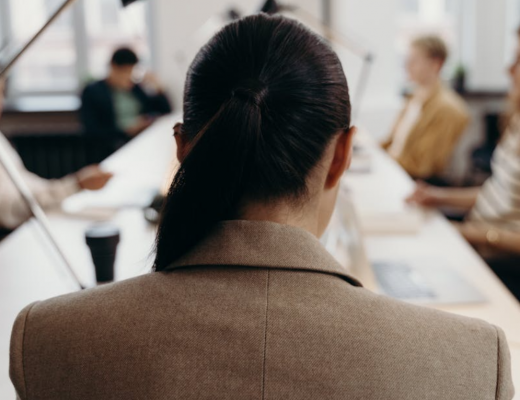 The Back of a Woman's Head Sitting at a Conference Table