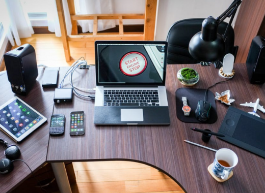 Laptop and Cell Phones Sitting on an Organized Desk