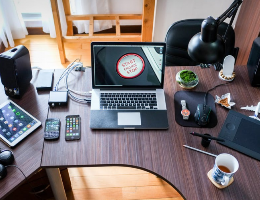 Laptop and Cell Phones Sitting on an Organized Desk