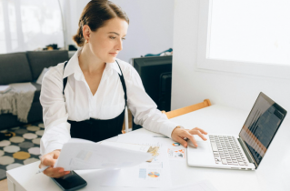 Caucasian Business Woman Sitting at a Desk and Working on a Laptop