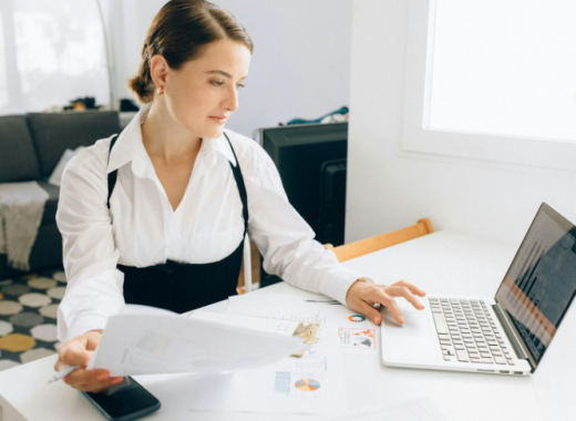 Caucasian Business Woman Sitting at a Desk and Working on a Laptop