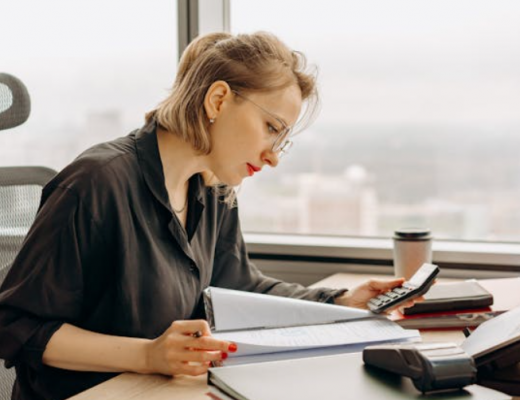 Woman Sitting at a Desk and Looking at Paperwork