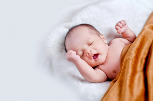 Yawning Baby Wrapped in Orange Blanket