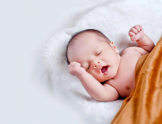 Yawning Baby Wrapped in Orange Blanket