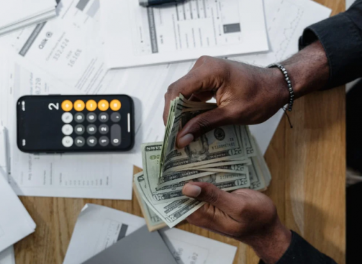 Woman Sitting at a Desk and Counting Money