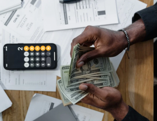 Woman Sitting at a Desk and Counting Money