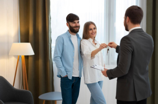 Woman and Man Shaking Hands to Get Keys to Their New Home