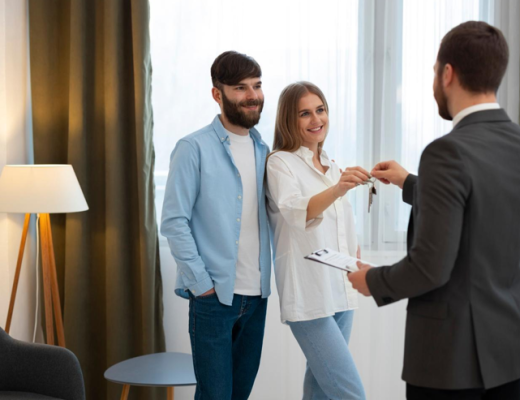 Woman and Man Shaking Hands to Get Keys to Their New Home
