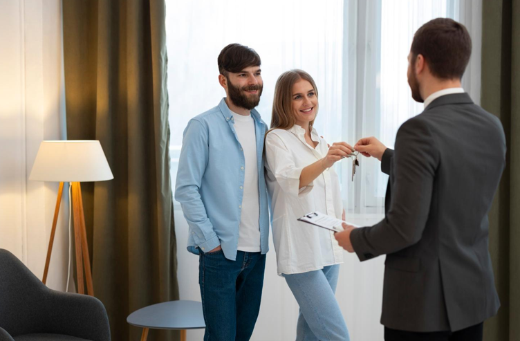 Woman and Man Shaking Hands to Get Keys to Their New Home