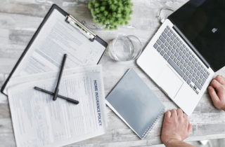 Laptop Sitting on a Desk with a Clipboard