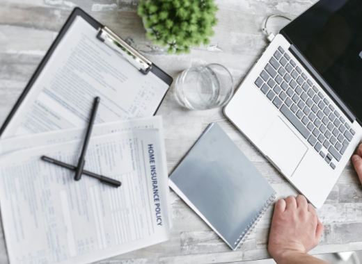 Laptop Sitting on a Desk with a Clipboard