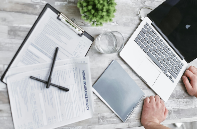 Laptop Sitting on a Desk with a Clipboard