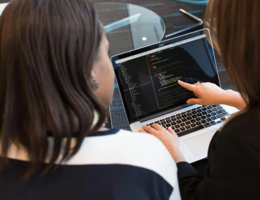 2 Women Looking at Code on a Computer Screen