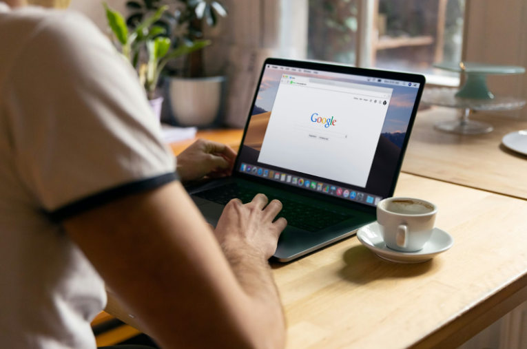 Woman Sitting at a Desk and Looking at Google Search on Her Laptop