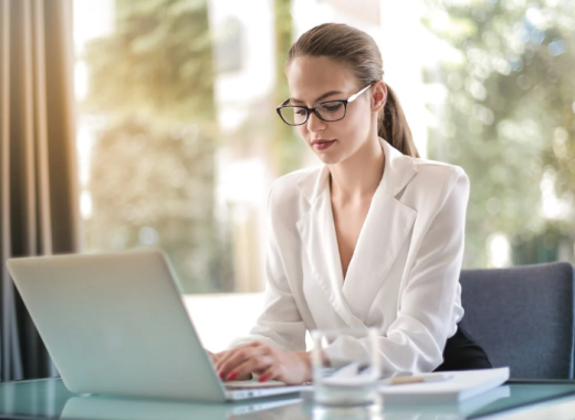 Caucasian Woman Wearing a White Blouse and Sitting at a Desk