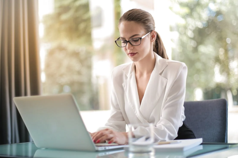 Caucasian Woman Wearing a White Blouse and Sitting at a Desk