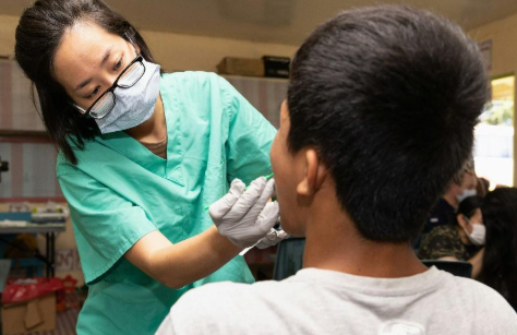 Asian Dental Hygienist with a Patient
