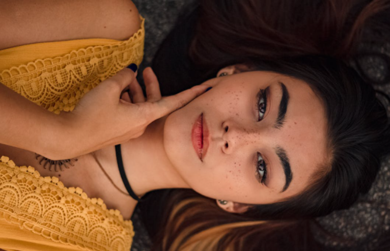 Indian Woman Dressed in Yellow and Laying Sideways on the Ground