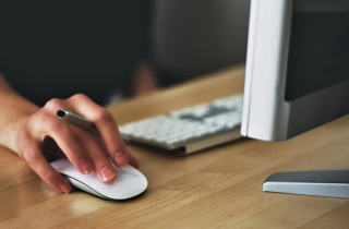 Woman with Her Hand Resting on an External Mouse