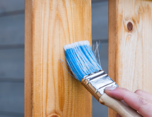 Paintbrush Up Against a Wooden Board