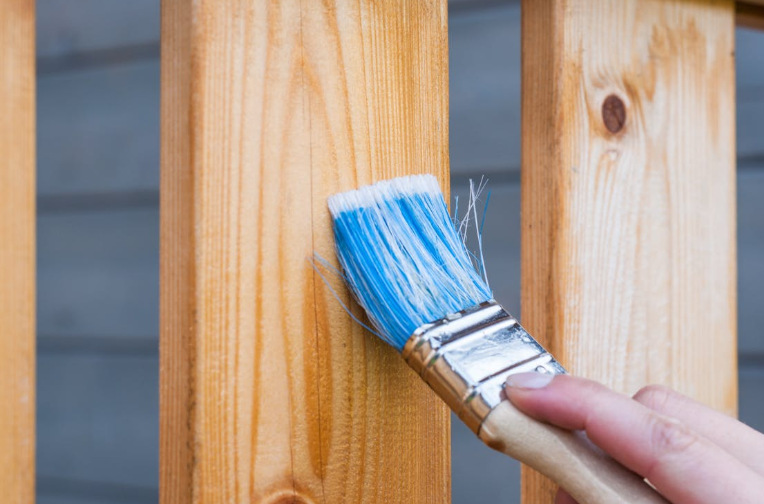 Paintbrush Up Against a Wooden Board