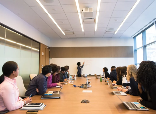 Group of People Sitting Around a Business Conference Table