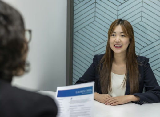 Woman Interviewing a Smiling Asian Woman for a Job Interview
