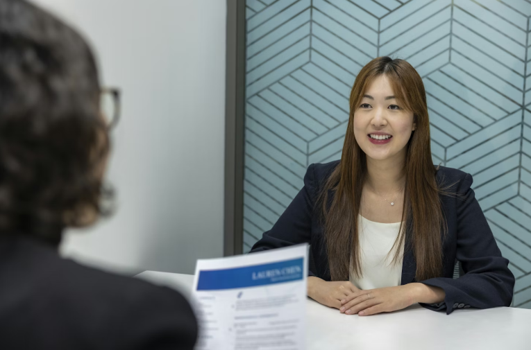 Woman Interviewing a Smiling Asian Woman for a Job Interview